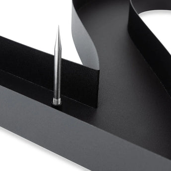 Close-up van de Carlo Black 20cm van yessential.nl, een modern zwart metalen huisnummer met een gebogen rand en verticale zilveren spike. Het 3D-ontwerp steekt af tegen de witte achtergrond voor een strakke, eigentijdse look.