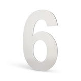 Een metallic nummer 6 staat rechtop op een witte achtergrond en werpt een vage schaduw naar links. Het yessential.nl Animo RVS 15cm (geen boor) ontwerp voegt een modern tintje toe aan elke woning.