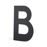 Een krachtige, effen zwarte letter B in Adamo Black 15cm van yessential.nl valt op tegen een effen witte achtergrond - ideaal als modern rvs huisnummer of huisnummer zwart accent voor je huis.