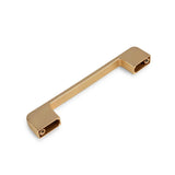 De Ramiro Gold Deluxe van yessential.nl is een rechthoekige, goudkleurige metalen greep met strakke, moderne lijnen en bevestigingsgaten aan de uiteinden-perfect als keukenkast greep. Afgebeeld op een witte achtergrond.