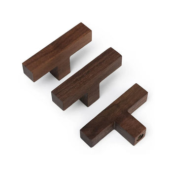 Drie Vigio Walnut Knobs van yessential.nl in donkerbruin op een witte achtergrond. De T-vormige houten knoppen zijn in verschillende hoeken geplaatst om het elegante ontwerp en de kwaliteit van het vakmanschap te laten zien.