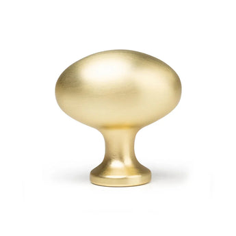 De Agero Gold Knop Deluxe van yessential.nl is een ovaalvormige meubelknop met een gladde, geborstelde gouden afwerking en een korte ronde voet, afgebeeld tegen een witte achtergrond.