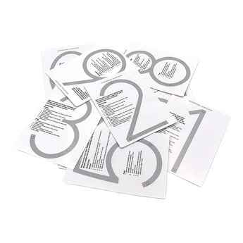 Een stapeltje Amato White 12,5cm stencils van yessential.nl met grote grijze cijfers 0-9 en begeleiding op elk vel. Door ze over elkaar te leggen kun je stijlvolle witte huisnummers displays maken.
