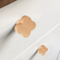 Close-up van twee lichtgekleurde Bambino Clover meubelknoppen van yessential.nl, in de vorm van een wolk en bevestigd aan een witte commode - perfect voor een kinderkamer.