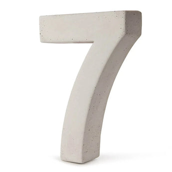 Een groot, driedimensionaal nummer 7 van lichtgrijs beton staat rechtop tegen een witte achtergrond - dit is het Enrico beton 30cm huisnummer van yessential.nl.