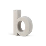 De Enrico beton 20cm van yessential.nl is een driedimensionaal, lichtgrijs betonnen huisnummer in de vorm van de letter "b", dat rechtop staat op een witte achtergrond.