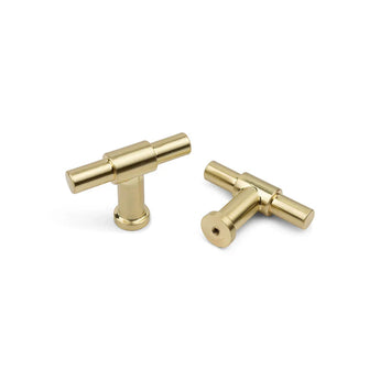 Twee moderne, cilindervormige Cordero Gold kastknoppen van yessential.nl worden weergegeven op een witte achtergrond; de ene staat rechtop terwijl de andere op zijn kant ligt.