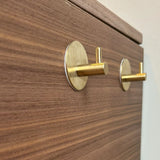 Close-up van twee gouden 4x Rudro Hooks 3M van yessential.nl horizontaal gemonteerd op lichtbruin hout met een zichtbaar nerfpatroon.