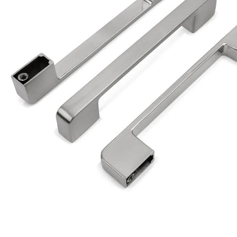 Drie Ramiro Chrome Deluxe kastgrepen van yessential.nl zijn diagonaal gerangschikt op een witte achtergrond, waarbij hun gepolijste bovenkanten en open uiteinden voor schroefmontage zichtbaar zijn.