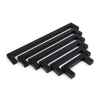 Zes Vasco Black Knobs van yessential.nl, met een matte afwerking en rechthoekige vorm, staan op een rij van groot naar klein op een witte achtergrond, allemaal in dezelfde richting.