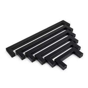 Een set van zes Vasco Black rechthoekige zwarte keuken handgrepen van yessential.nl, gerangschikt in aflopende grootte en parallel opgesteld op een witte achtergrond.