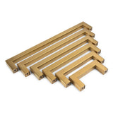 Zes Vigio Gouden Knoppen van yessential.nl in geborsteld messing, gerangschikt van klein naar groot, met een modern rechthoekig ontwerp-perfect als stijlvolle gouden vierkante kastgrepen of Vigio meubelknoppen accenten.