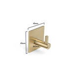 De Navarro Gold handdoekhaak van yessential.nl heeft een gouden vierkante basis (45x45mm) en cilindrische pin (26,5mm), afgebeeld op een witte achtergrond. Perfect als stijlvolle, zelfklevende handdoekhaak voor je badkamer.