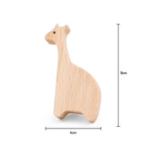 De Bambino Giraffe van yessential.nl is houten speelgoed in de vorm van een giraffe, 9 cm hoog en 4 cm breed, dat lijkt op een houten meubelknop giraf. Aan de rechter- en onderkant staan maatlijnen en labels.