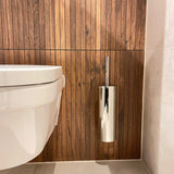Een modern wit wandcloset is gecombineerd met de Romano Chroom WC set van yessential.nl, tegen een verticale wand met houten panelen en een lichtgekleurde tegelvloer.