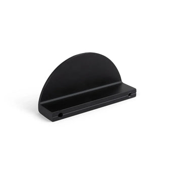 De Torno Black van yessential.nl is een matzwarte, halfronde metalen plank met een platte basis en twee montagegaten, geïnspireerd op halve maan handgrepen, afgebeeld tegen een effen witte achtergrond.