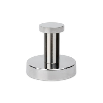 De Kyano Chroomhaak van yessential.nl is een glanzend zilver metalen stuk met een cilindrisch handvat en platte ronde basis, dat lijkt op een handdoekhaak badkamer of koffie tamper, weergegeven tegen een witte achtergrond.