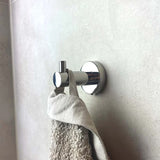 De Lorenzo Chroom Wc-set van yessential.nl houdt een beige handdoek en grijze doek op een lichtgekleurde betegelde wand en voegt stijlvolle functionaliteit toe aan je badkamer.