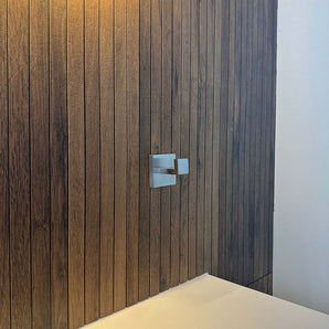 Een RVS handdoekhaak met een vierkante rozet, is gemonteerd op een verticaal houten paneel.