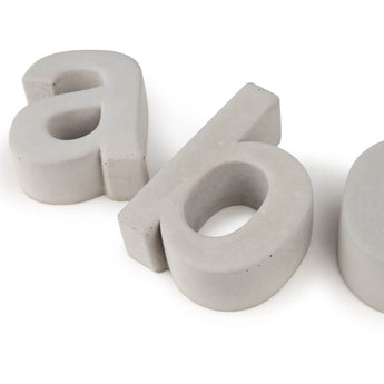 De Enrico beton 20cm van yessential.nl heeft een betonnen kleine letter "a" en de rand van een andere letter in een glad, blokkerig lettertype op een witte achtergrond-perfect als stijlvol huisnummer.