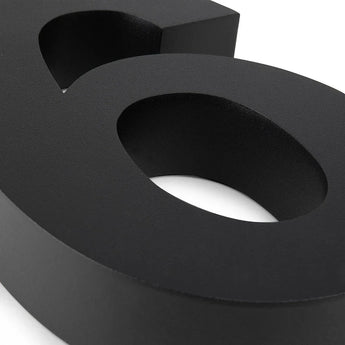 Een close-up van de Angelo Black 20cm van yessential.nl, een strakke 3D zwarte ampersand (&) op een witte achtergrond - moderne stijl geïnspireerd op huisnummers.