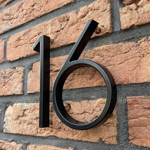 De Amato Black 12,5cm huisnummers van yessential.nl zijn gemonteerd op rode bakstenen muren en staan iets weg om een subtiele schaduw te werpen voor een moderne zwarte look.