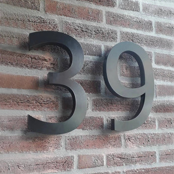 De Carlo Black 20cm van yessential.nl is een modern zwart 3D huisnummer 39, perfect voor op een rode bakstenen muur en dankzij het formaat van 20 cm goed zichtbaar.