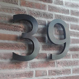 De Carlo Black 20cm van yessential.nl is een modern zwart 3D huisnummer 39, perfect voor op een rode bakstenen muur en dankzij het formaat van 20 cm goed zichtbaar.