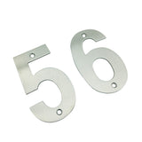 Twee Tonio RVS 10cm metalen huisnummers, 5 en 6, van yessential.nl, gemaakt van geborsteld roestvrij staal met voorgeboorde montagegaten, zijn afgebeeld op een witte achtergrond.