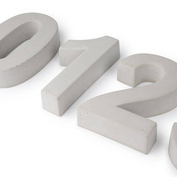 Enrico beton 20cm huisnummers "0", "1", en "2" door yessential.nl, met blauwachtig-grijs, driedimensionaal betonnen ontwerp met een gladde textuur-deels zichtbaar gerangschikt op een witte achtergrond.