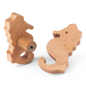 De Bambino Seahorse ladeknoppen van yessential.nl zijn houten meubelknoppen met een gladde afwerking en zichtbare houtnerf, ideaal voor een kinderkamer. Afgebeeld vanuit verschillende hoeken om hun vorm en schroefbevestiging te benadrukken.