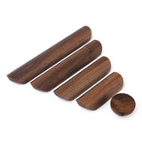 Vier houten handgrepen van verschillende lengtes en een Arriero Walnut knop van yessential.nl zijn gerangschikt op een witte achtergrond. Elk stuk heeft een gladde, gepolijste afwerking met een rijke bruine houtnerf voor een vleugje luxe in elke ruimte.