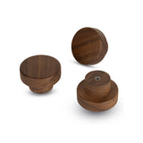Drie Arriero Walnut knoppen van yessential.nl worden getoond op een witte achtergrond vanuit verschillende hoeken, waardoor hun gladde afwerking en houtnerf wordt benadrukt. Eén knop toont de zichtbare schroefaansluiting aan de achterkant.