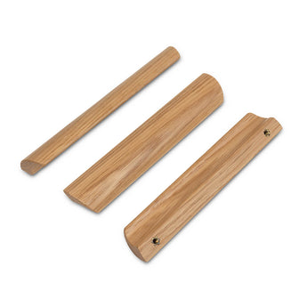 Drie houten deurstoppers in verschillende vormen en groeven, weergegeven op een witte achtergrond. Gemaakt van licht eikenhout met gladde oppervlakken - ze passen perfect bij de Lucasso Oak handgrepen van yessential.nl.