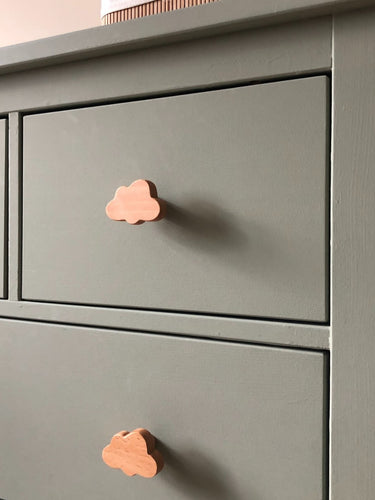 Een close-up van een saliegroen dressoir met Bambino Cloud houten meubelknop van yessential.nl in een speels wolkendessin. De gladde, matte afwerking en eenvoudige lijnen maken het perfect voor een minimalistische en vrolijke kinderkamer.