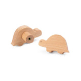 De Bambino Dino ladeknoppen van yessential.nl zijn voorzien van twee lichthouten schildpadden - de ene toont een zijprofiel, de andere een achteraanzicht met metalen schroef - ideaal als houten meubelknop voor de kinderkamer.