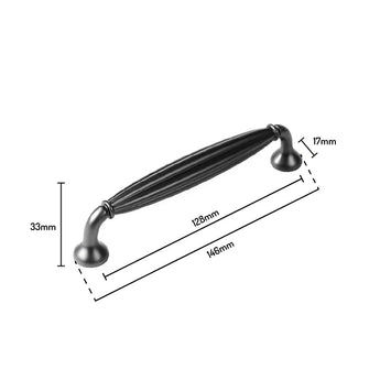 De Alvaro Antraciet van yessential.nl is een zwarte handgreep in klassieke stijl met decoratieve ribbels, met een lengte van 146 mm, een gatafstand van 128 mm, een hoogte van 33 mm en een breedte van 17 mm - ideaal voor het opwaarderen van je zinken kastgrepen.