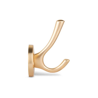 De Eduardo Gold Deluxe van yessential.nl is een stijlvolle messingkleurige haak met twee gebogen tanden op een ronde basis, tegen een effen witte achtergrond.
