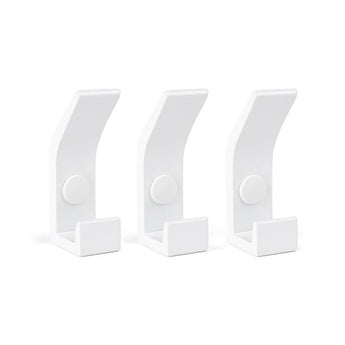 Drie identieke Huso White kapstokhaken van yessential.nl, met een moderne minimalistische uitstraling, staan in een rij op een effen witte achtergrond. Elke haak heeft een platte basis, een gebogen arm en een centraal cirkelvormig accent.