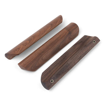 Drie Lucasso Walnut handgrepen van yessential.nl worden getoond op een witte achtergrond, met een gladde afwerking, unieke randvormen en twee stervormige schroefgaten - ideaal voor een natuurlijke inrichting.