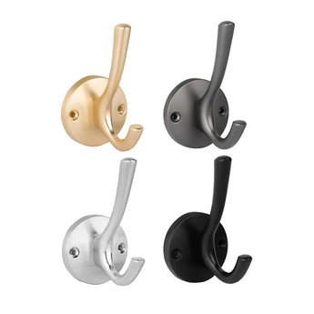 Vier dubbele wandhaken van yessential.nl worden getoond in een raster met verschillende afwerkingen: goud, donkergrijs, zilver en Eduardo Black Deluxe. Elke haak heeft een ronde basis met twee schroeven en twee tanden om voorwerpen aan op te hangen.