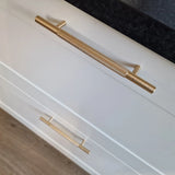 Close-up van twee Remo Gold Deluxe lades van yessential.nl, met elegante gouden handgrepen, tegen een donker aanrechtblad en een lichte houten vloer.
