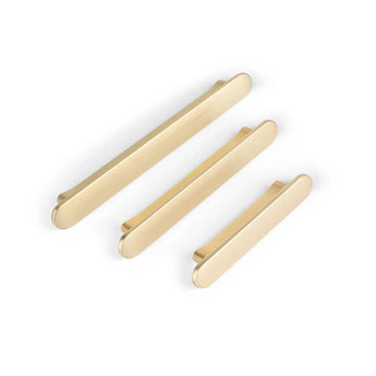 Drie Arriero Gold Deluxe handgrepen van yessential.nl, met een moderne gouden afwerking en verschillende lengtes, worden diagonaal weergegeven tegen een effen witte achtergrond.