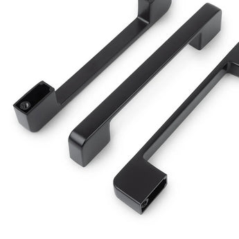 Drie strakke Ramiro Black Deluxe handgrepen van yessential.nl, elk met scherpe randen en zichtbare schroefgaten, staan diagonaal op een witte achtergrond.