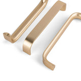 Drie Leonardo Gold Deluxe kastgrepen van yessential.nl, in een strak, rechthoekig goudkleurig ontwerp, zijn gerangschikt op een witte achtergrond - twee plat gelegd en een schuin om verschillende perspectieven weer te geven.