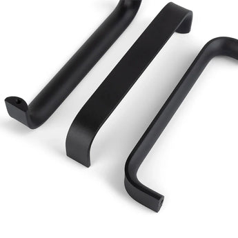 Drie Leonardo Black Deluxe handgrepen van yessential.nl worden getoond op een wit oppervlak, elk met een strak, modern ontwerp met afgeronde hoeken en gladde randen vanuit verschillende perspectieven.