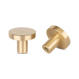 Twee ronde, goudkleurige Marizo Gold kastknoppen van yessential.nl worden getoond - één rechtop en één op zijn kant om de achterkant te onthullen. Perfecte elegante meubelknop of Marizo knopjes voor een moderne touch.