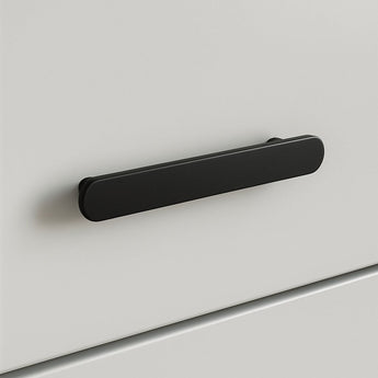 Een close-up van de Arriero Black Deluxe, een matzwarte, afgeronde rechthoekige handgreep van yessential.nl, bevestigd aan een glad wit ladefront-een modern voorbeeld van stijlvolle handgrepen.
