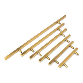 Vijf Marano Gold handgrepen van yessential.nl met een minimalistisch, modern ontwerp in verschillende lengtes zijn diagonaal opgesteld op een witte achtergrond.
