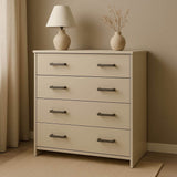De Vasco Gunmetal commode van yessential.nl heeft vier lades met gunmetal handgrepen en staat in een neutrale kamer. Bovenop staan een crèmekleurige lamp en een vaas met gedroogde takken, geplaatst bij een raam met lichte gordijnen.